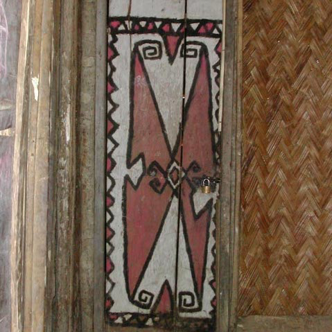 Telefomin war shield painted design on door of a more modern village house, West Sepik Province, Papua New Guinea, circa 2004.