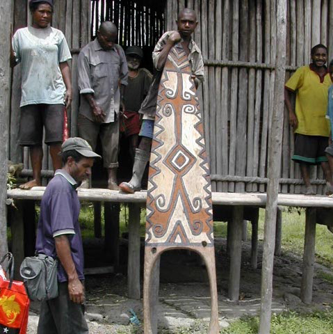 One of my main men, Raymond Kuaru in blue shirt and cap inspecting a nice Telefomin doorboard, amitung, West Sepik Province, Papua New Guinea, circa 2004/5.